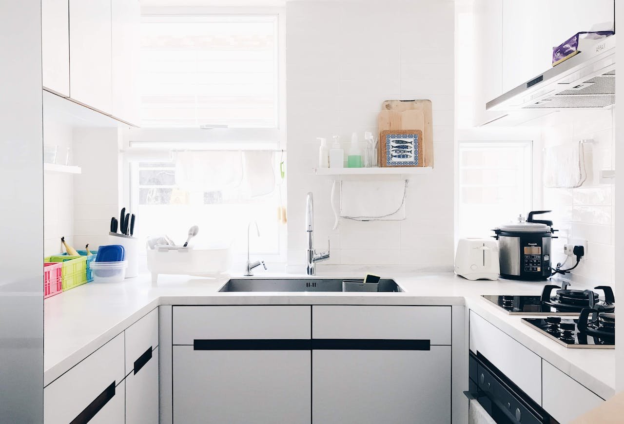 A clean and bright minimalist kitchen with stainless steel appliances and modern design.